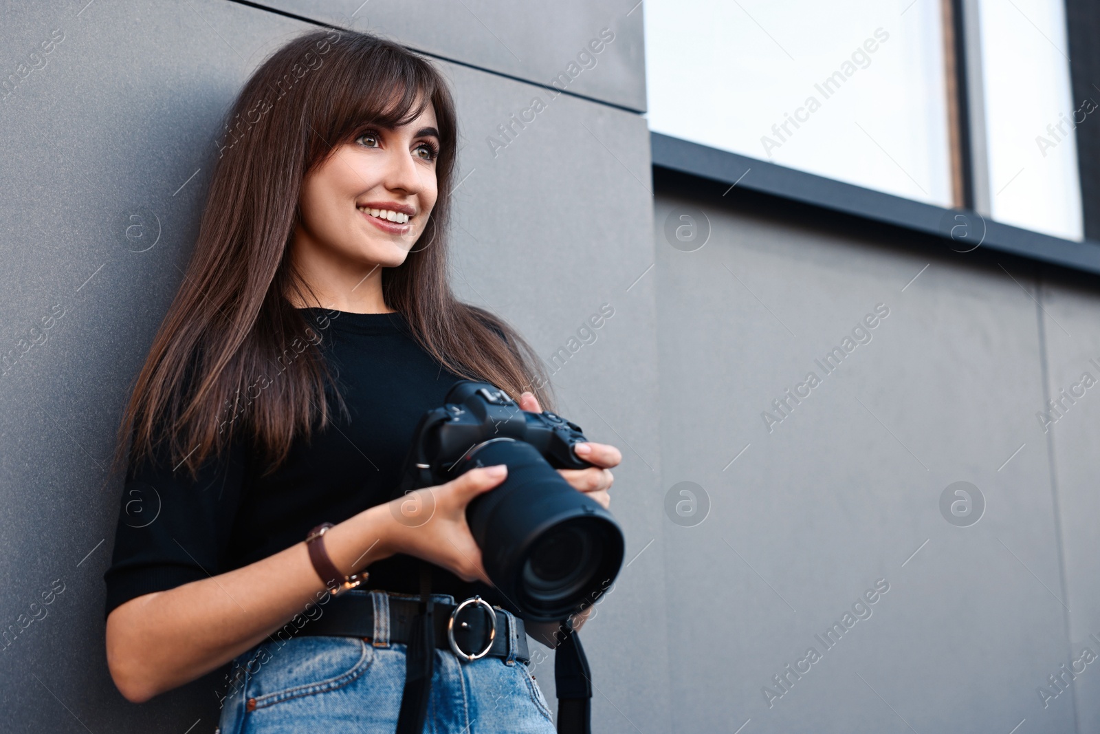 Photo of Professional photographer with digital camera near building outdoors. Space for text