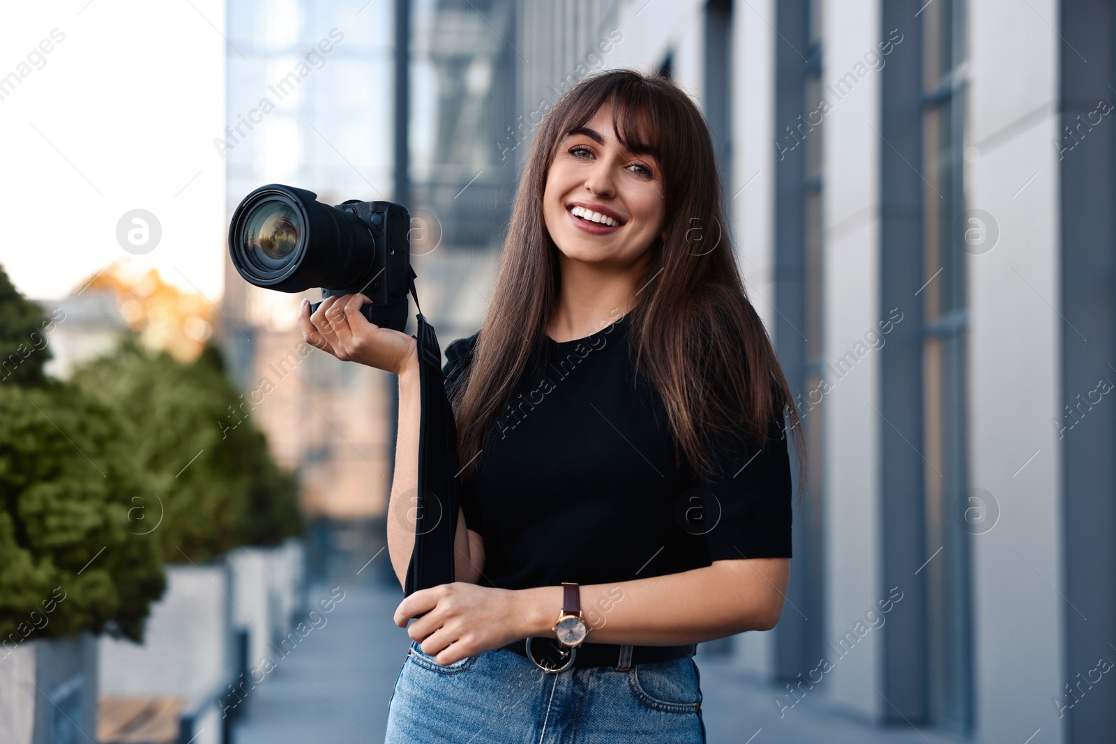 Photo of Professional photographer with digital camera near building outdoors