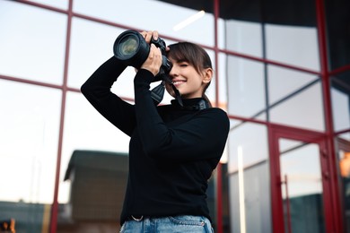 Photo of Professional photographer taking picture with camera outdoors