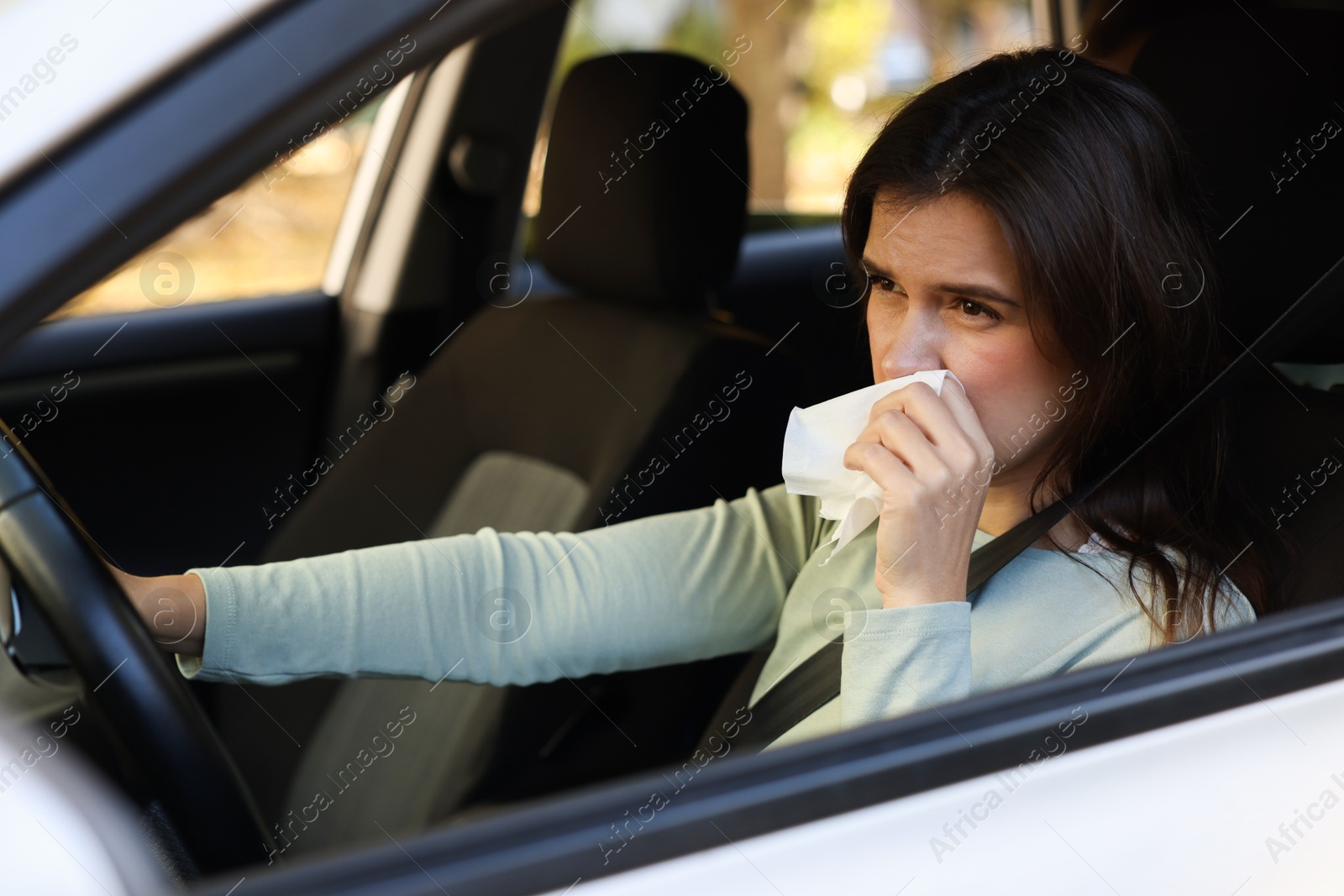 Photo of Young woman with runny nose in car