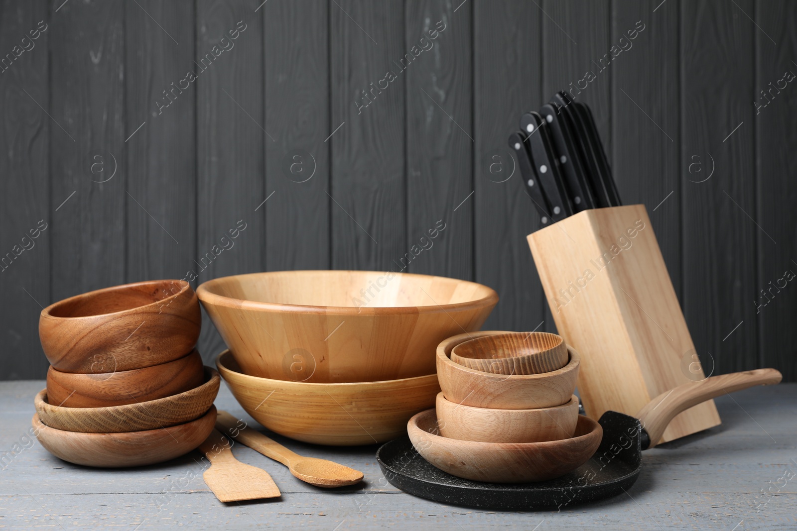 Photo of Dishware and cooking utensils on grey wooden table