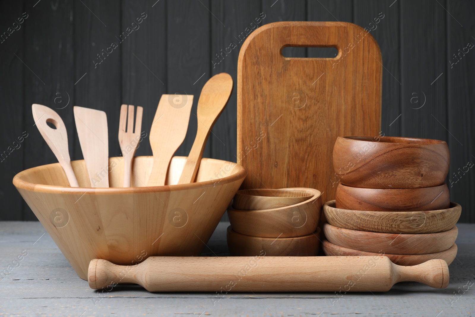 Photo of Dishware and cooking utensils on grey wooden table