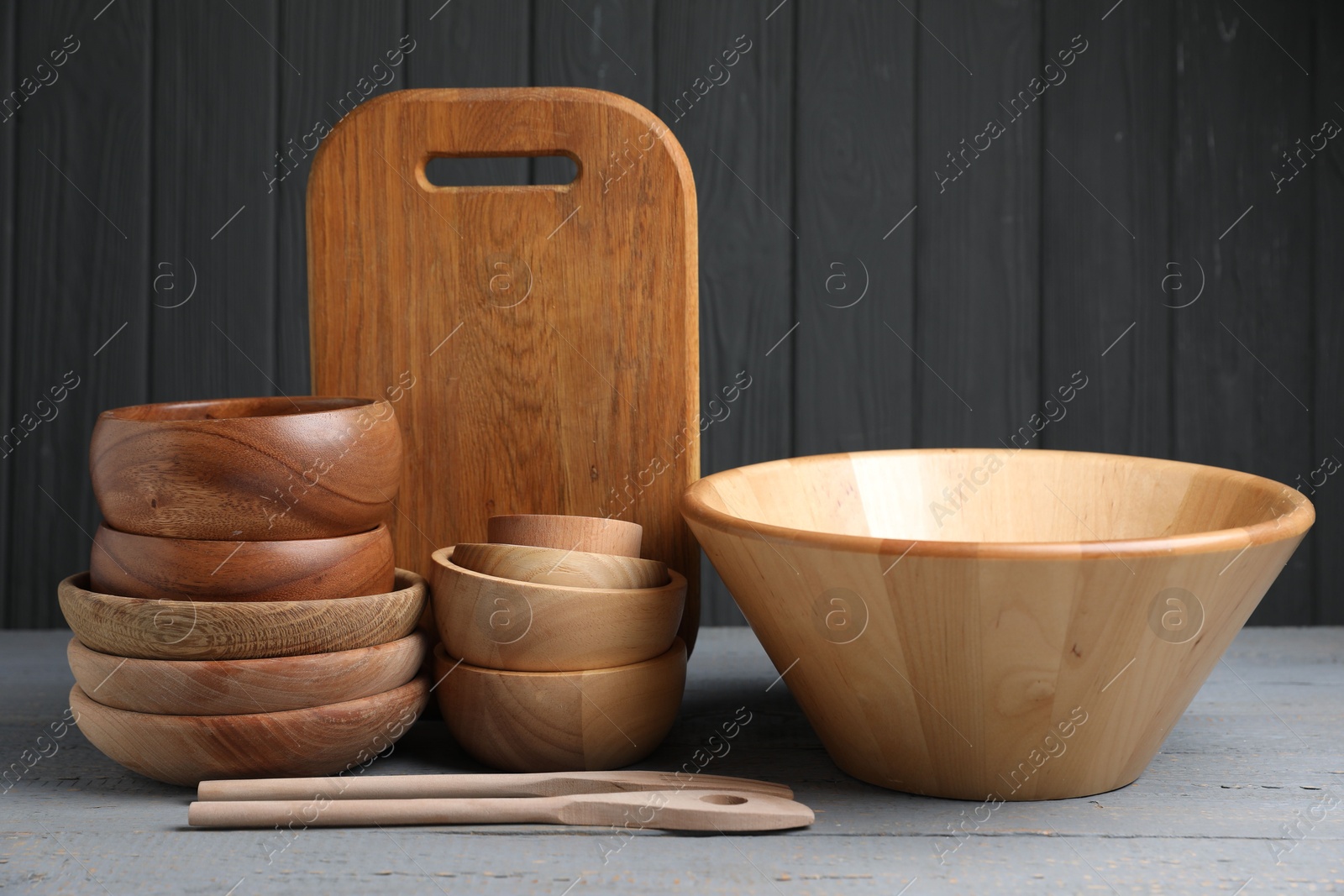 Photo of Dishware and cooking utensils on grey wooden table