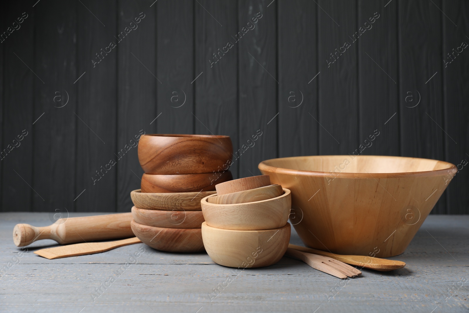 Photo of Dishware and cooking utensils on grey wooden table