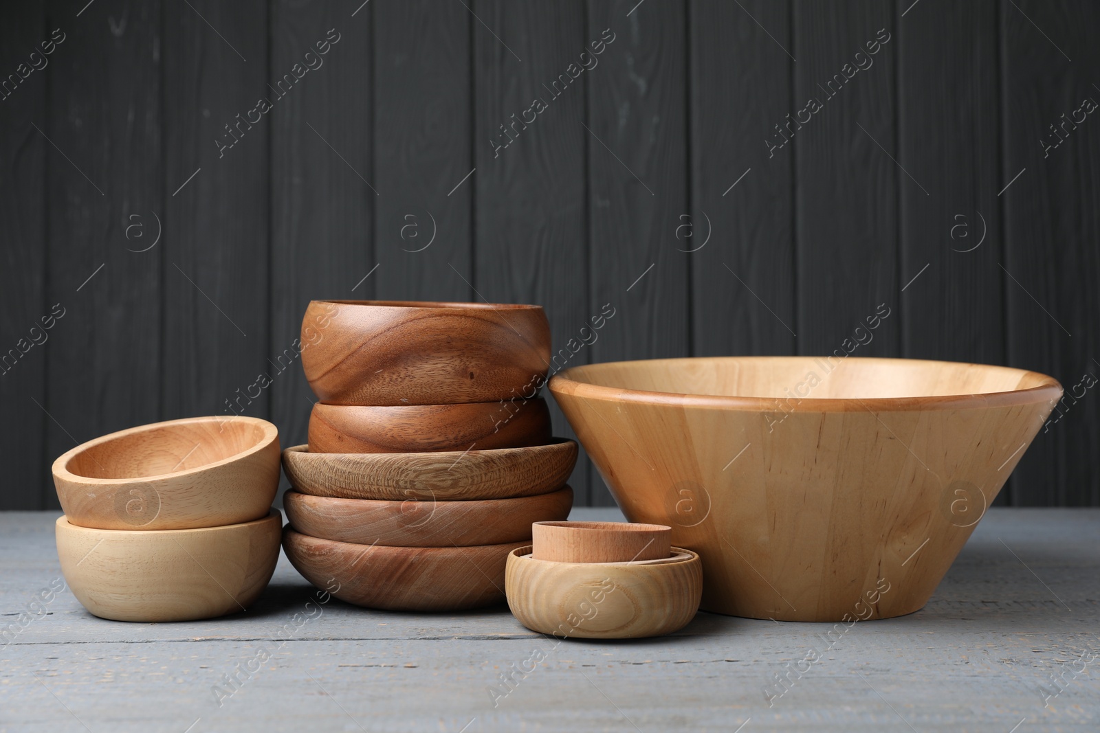 Photo of Wooden bowls on grey table. Cooking utensils