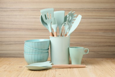 Dishware and cooking utensils on wooden table