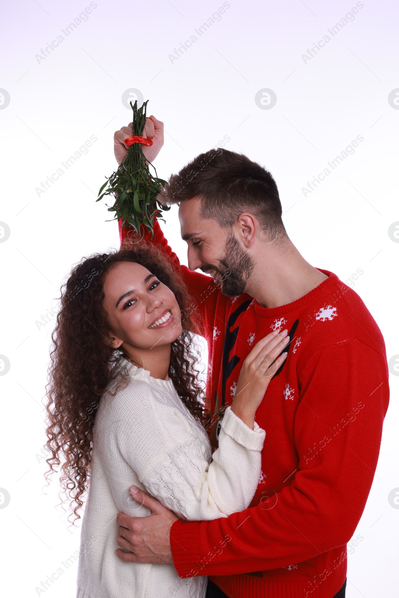 Photo of Lovely couple under mistletoe bunch on white background