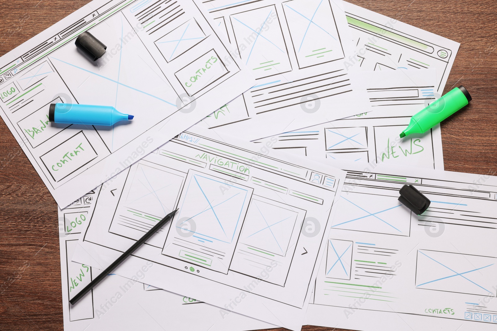 Photo of Developing UI design. Sketches of website wireframes and stationery on wooden table, top view