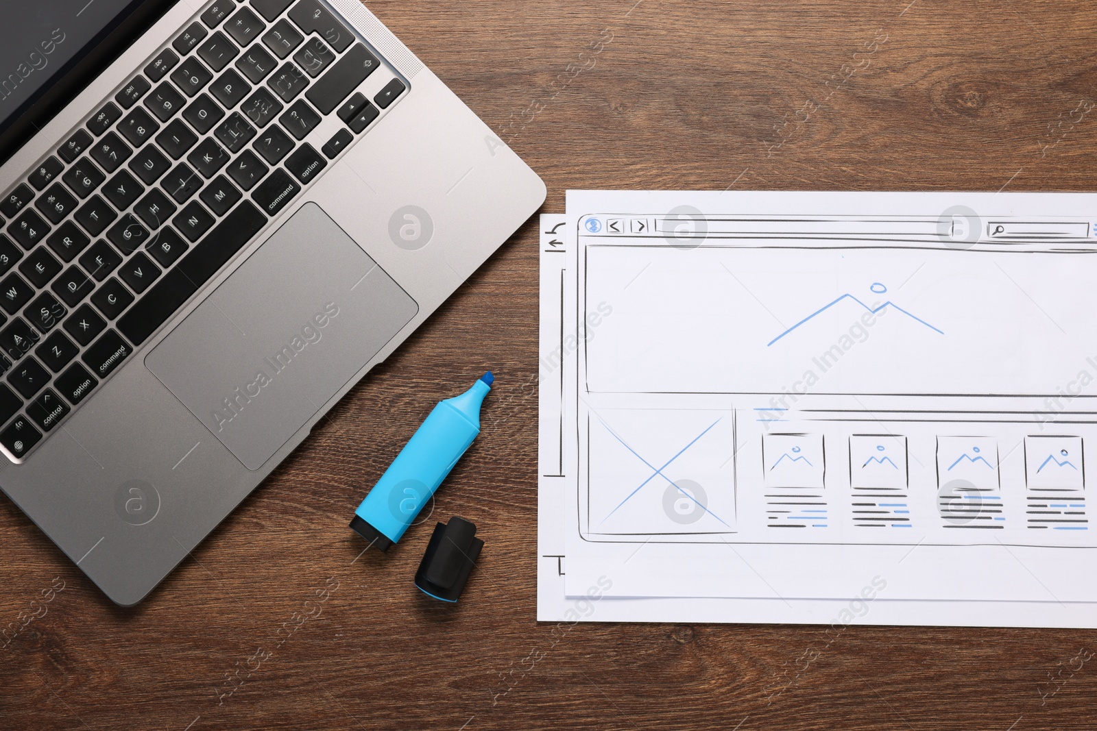 Photo of Developing UI design. Sketches of website wireframes, laptop and felt pen on wooden table, top view