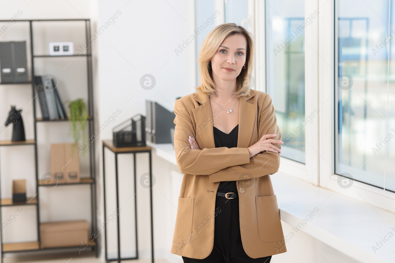 Photo of Portrait of happy businesswoman near window in office