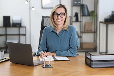 Photo of Happy businesswoman working at table in office