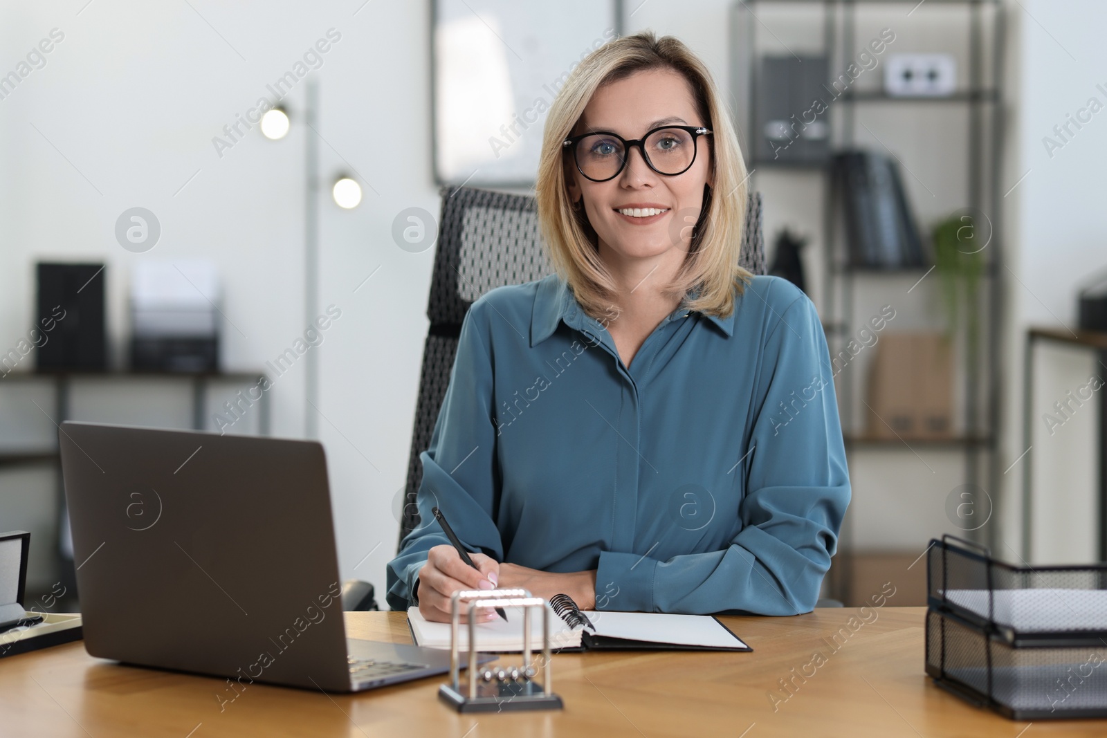 Photo of Happy businesswoman working at table in office