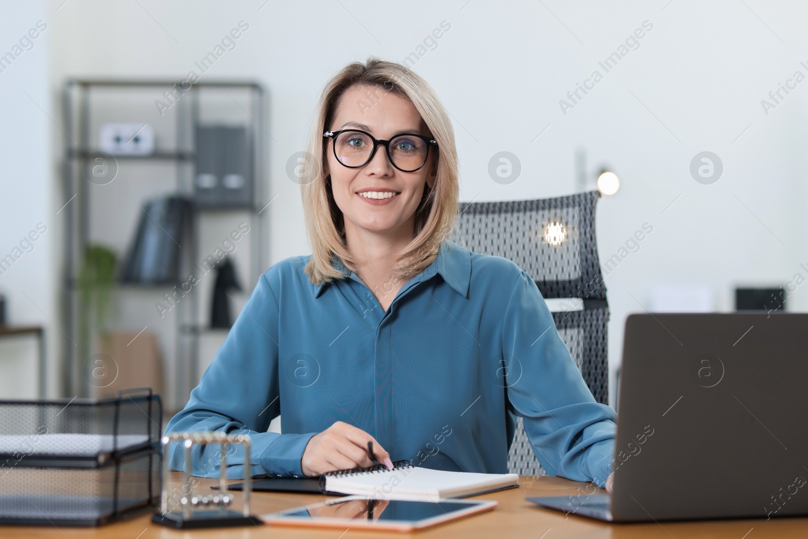 Photo of Businesswoman working on laptop at table in office