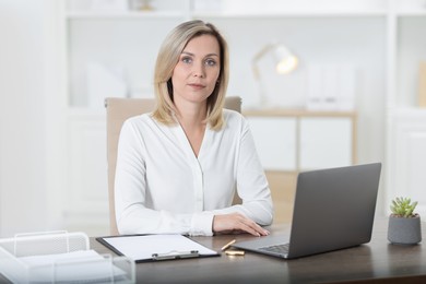 Photo of Portrait of businesswoman at table in office