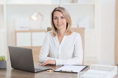 Photo of Portrait of businesswoman at table in office