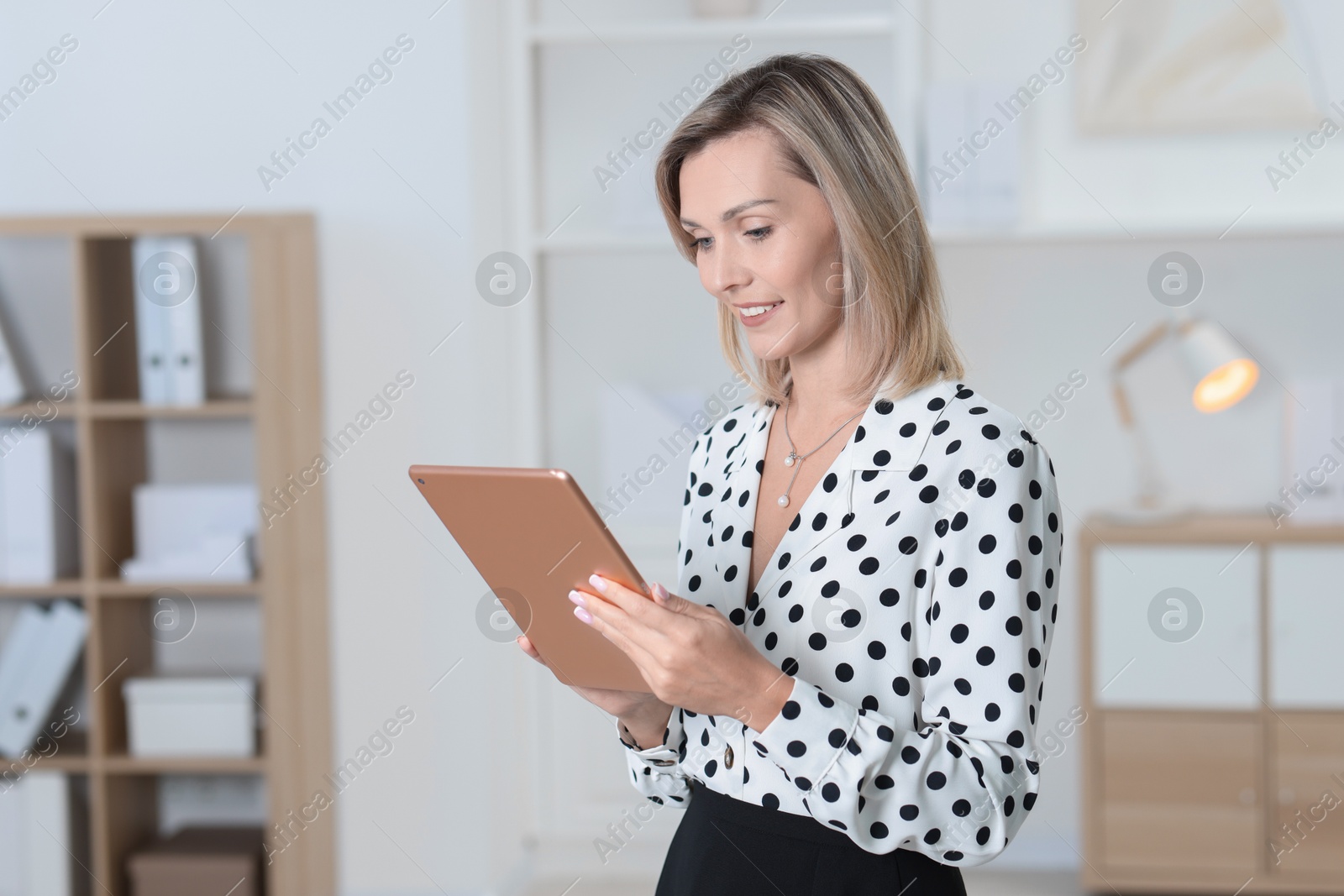 Photo of Portrait of happy businesswoman using tablet in office