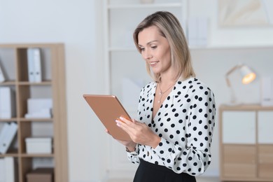 Photo of Portrait of happy businesswoman using tablet in office