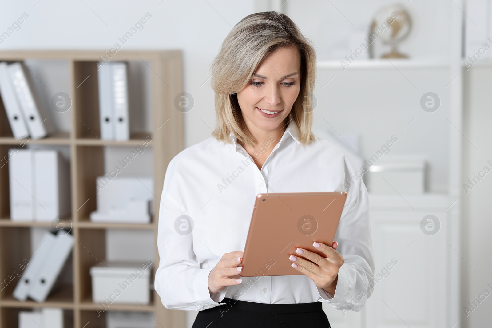 Photo of Portrait of happy businesswoman using tablet in office