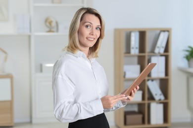 Photo of Portrait of happy businesswoman using tablet in office