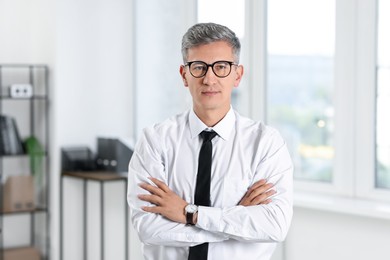 Photo of Portrait of businessman with crossed arms in office