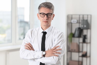 Photo of Portrait of businessman with crossed arms in office