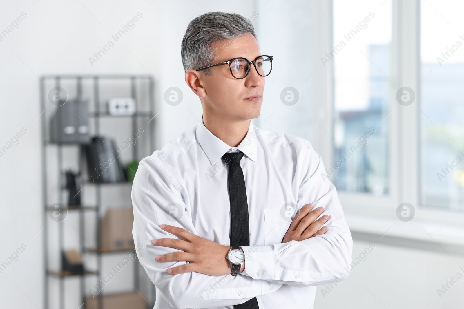 Photo of Portrait of businessman with crossed arms in office