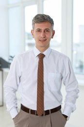 Photo of Portrait of handsome businessman posing in office