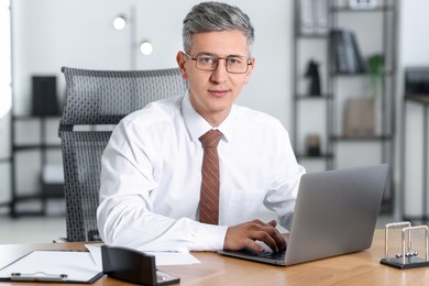 Businessman working on laptop at table in office