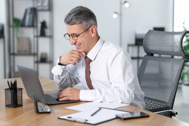 Businessman working on laptop at table in office