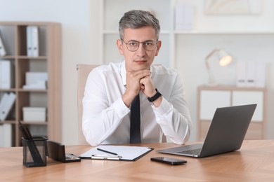 Photo of Portrait of businessman at table in office