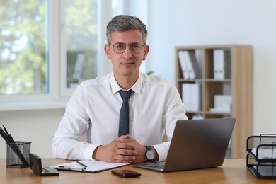 Photo of Portrait of businessman at table in office