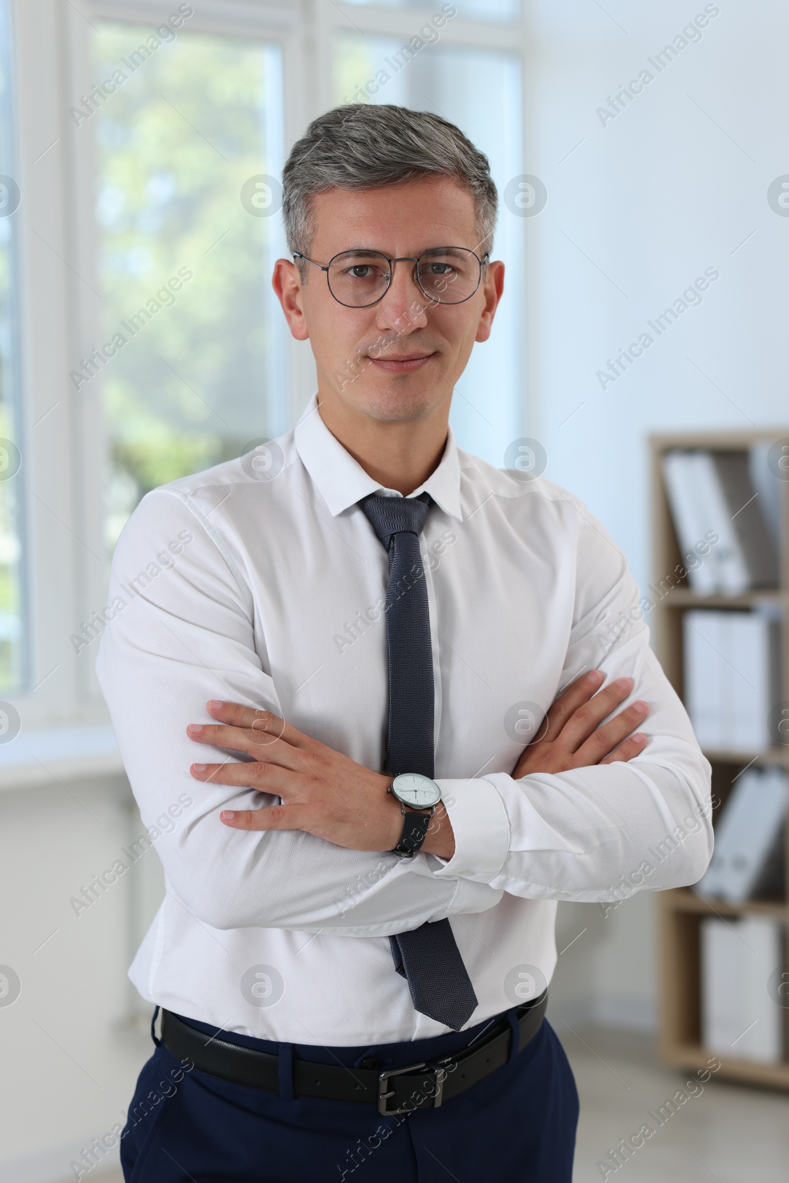 Photo of Portrait of businessman with crossed arms in office