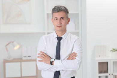 Photo of Portrait of businessman with crossed arms in office