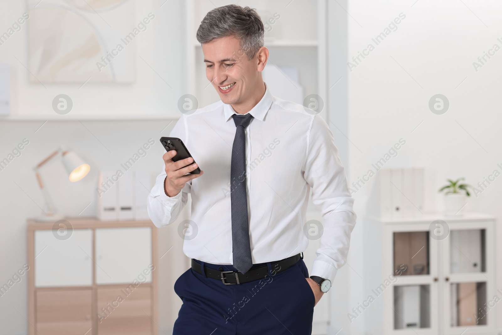 Photo of Portrait of businessman using smartphone in office