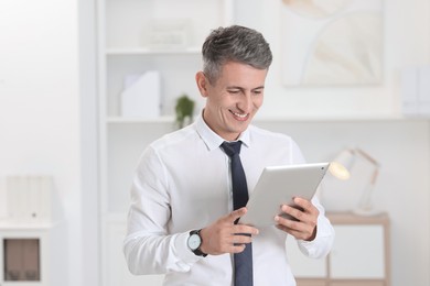 Photo of Portrait of businessman using tablet in office