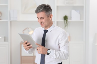 Photo of Portrait of businessman using tablet in office