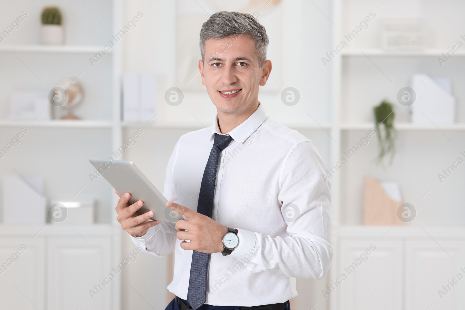 Photo of Portrait of businessman using tablet in office