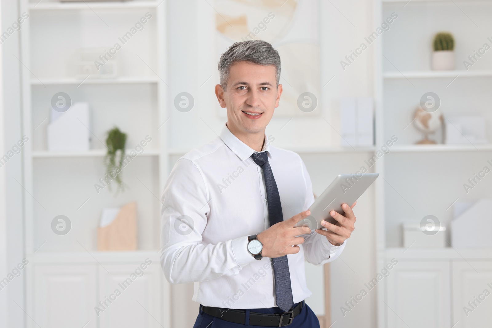 Photo of Portrait of businessman using tablet in office