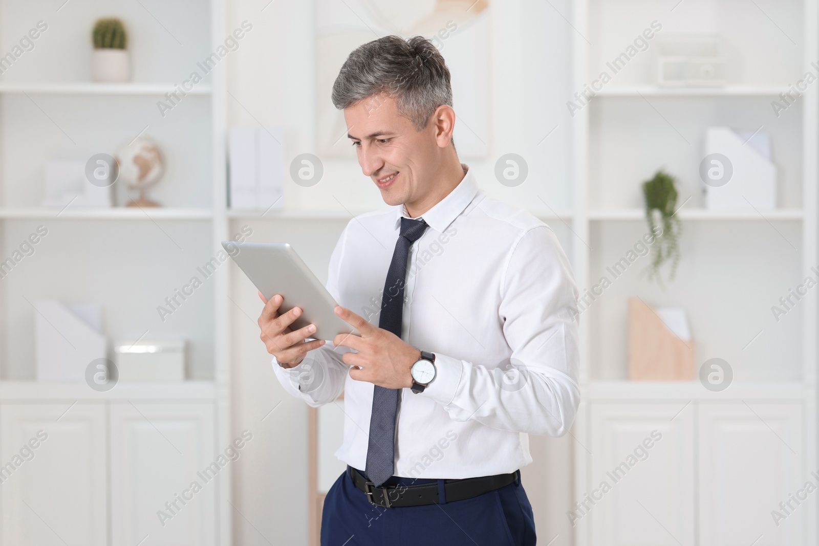 Photo of Portrait of businessman using tablet in office