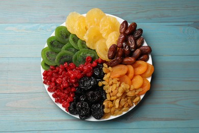 Photo of Mix of different dried fruits on light blue wooden table, top view