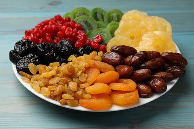 Photo of Mix of different dried fruits on light blue wooden table, closeup