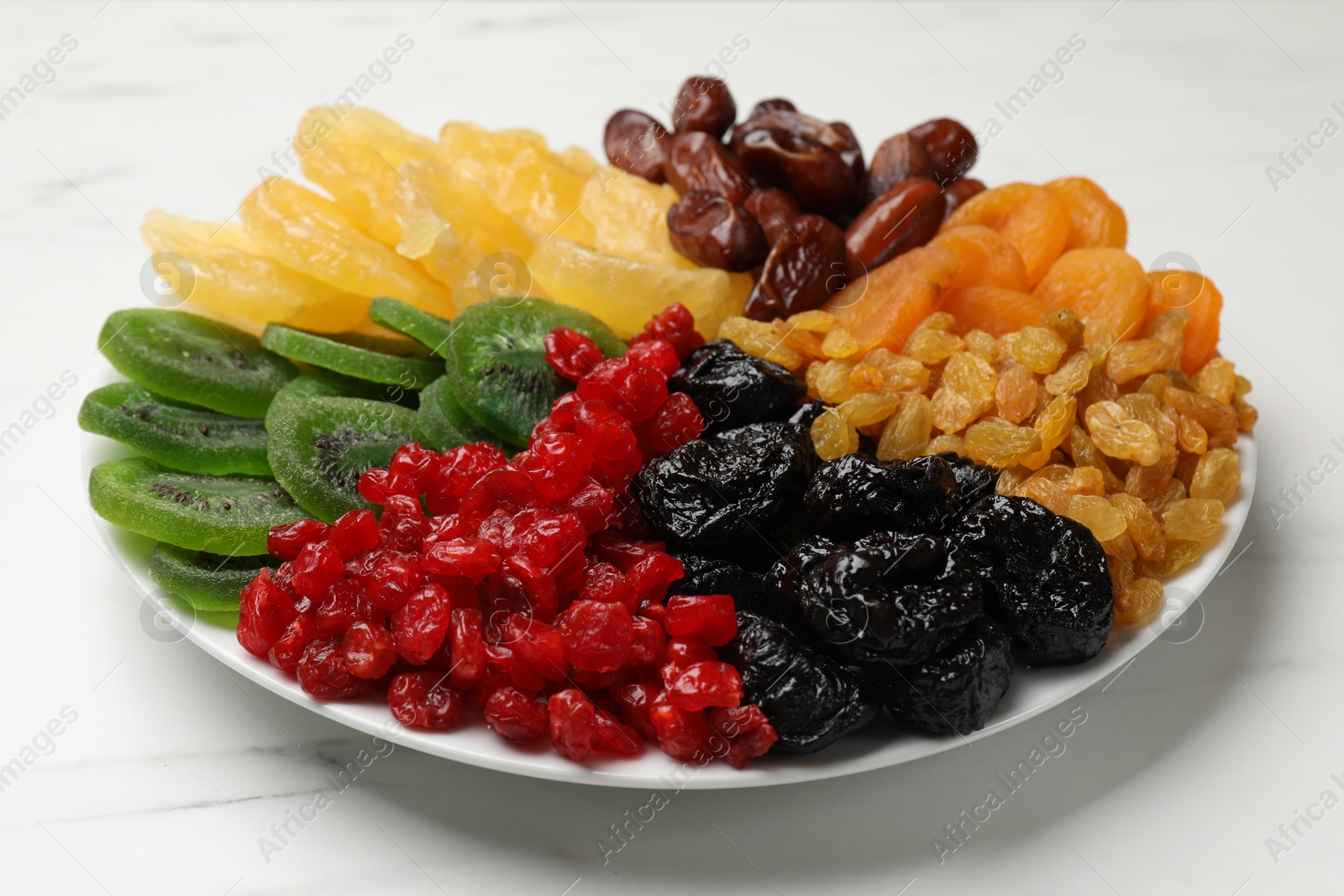 Photo of Mix of different dried fruits on white marble table, closeup