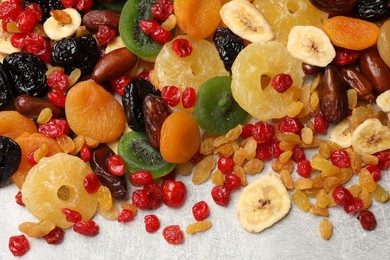 Photo of Mix of different dried fruits on gray textured table, top view