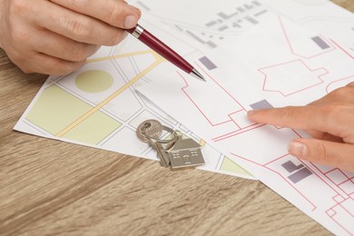 Real estate agent working with client at wooden table, closeup