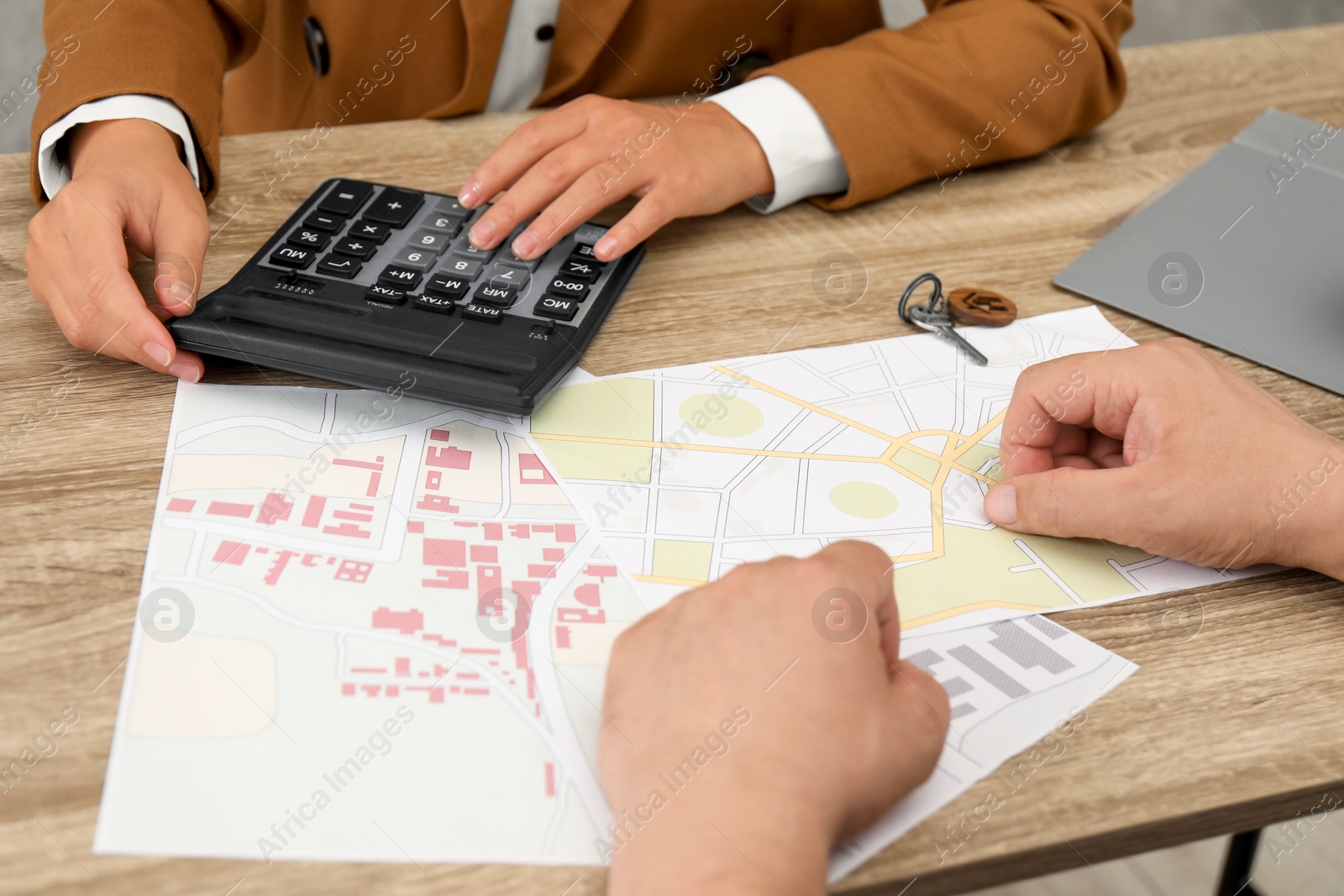 Photo of Real estate agent working with client at wooden table, closeup