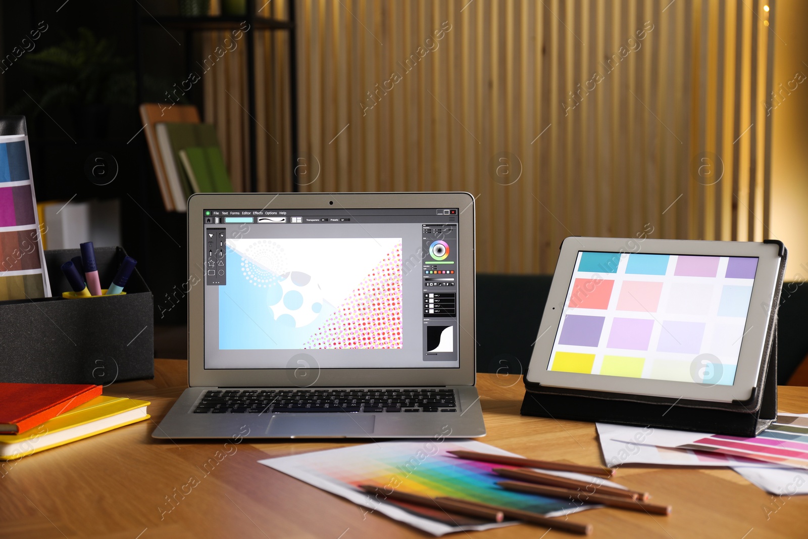 Photo of Designer's workplace with laptop, tablet, stationery and palettes on wooden table indoors