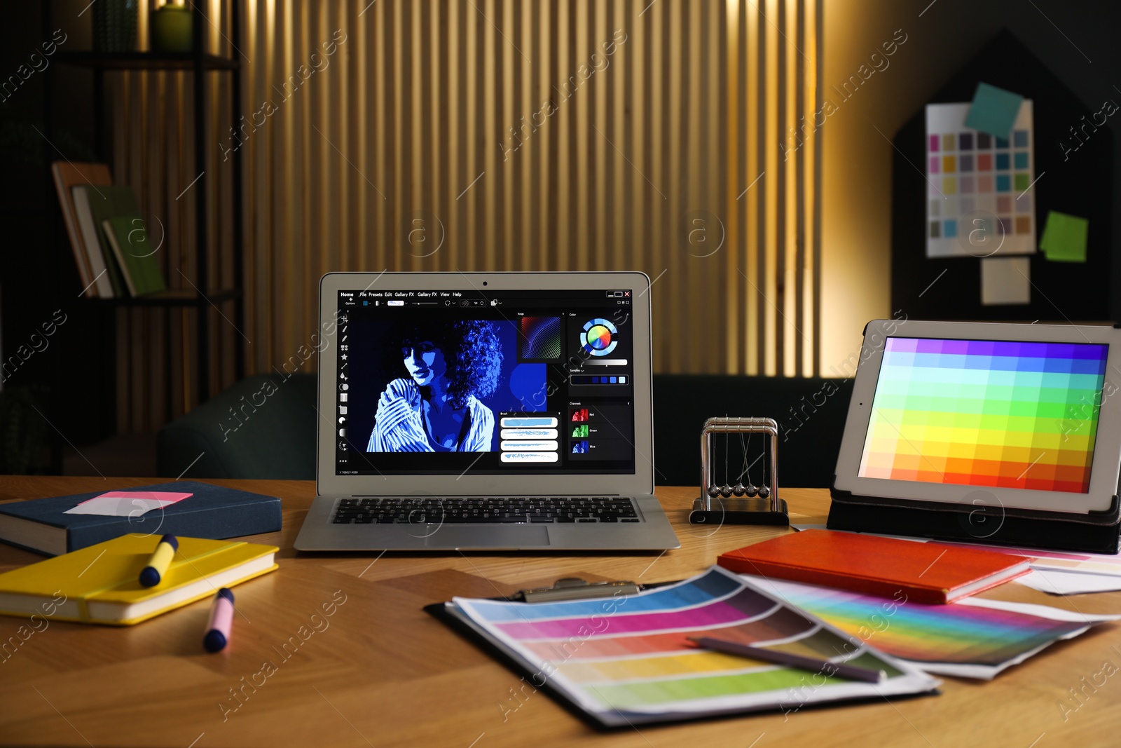 Photo of Designer's workplace with laptop, tablet, stationery and palettes on wooden table indoors