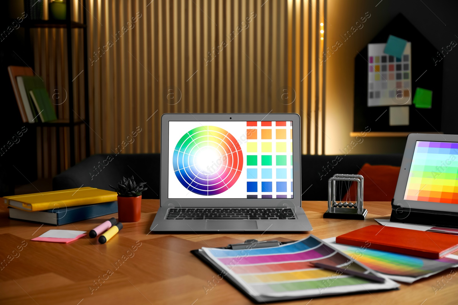 Photo of Designer's workplace with laptop, tablet, stationery and palettes on wooden table indoors