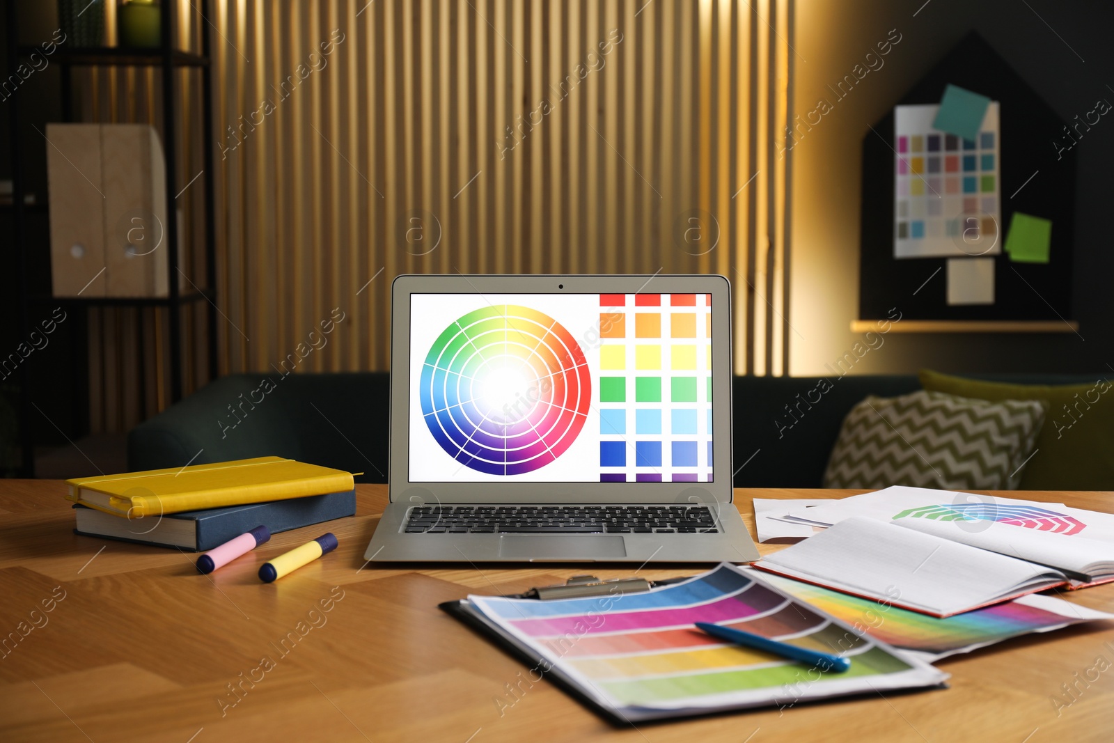 Photo of Designer's workplace with laptop, stationery and palettes on wooden table indoors