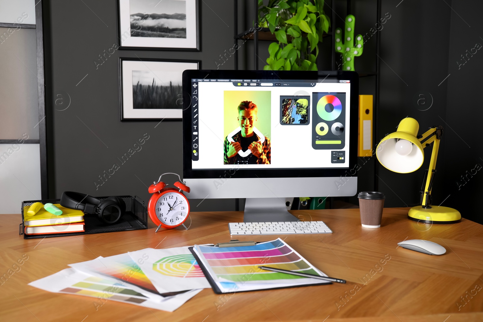 Photo of Designer's workplace with computer, stationery and palettes on wooden table indoors